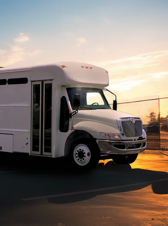 White shuttle bus parked next to a security fence at a prison near Boston